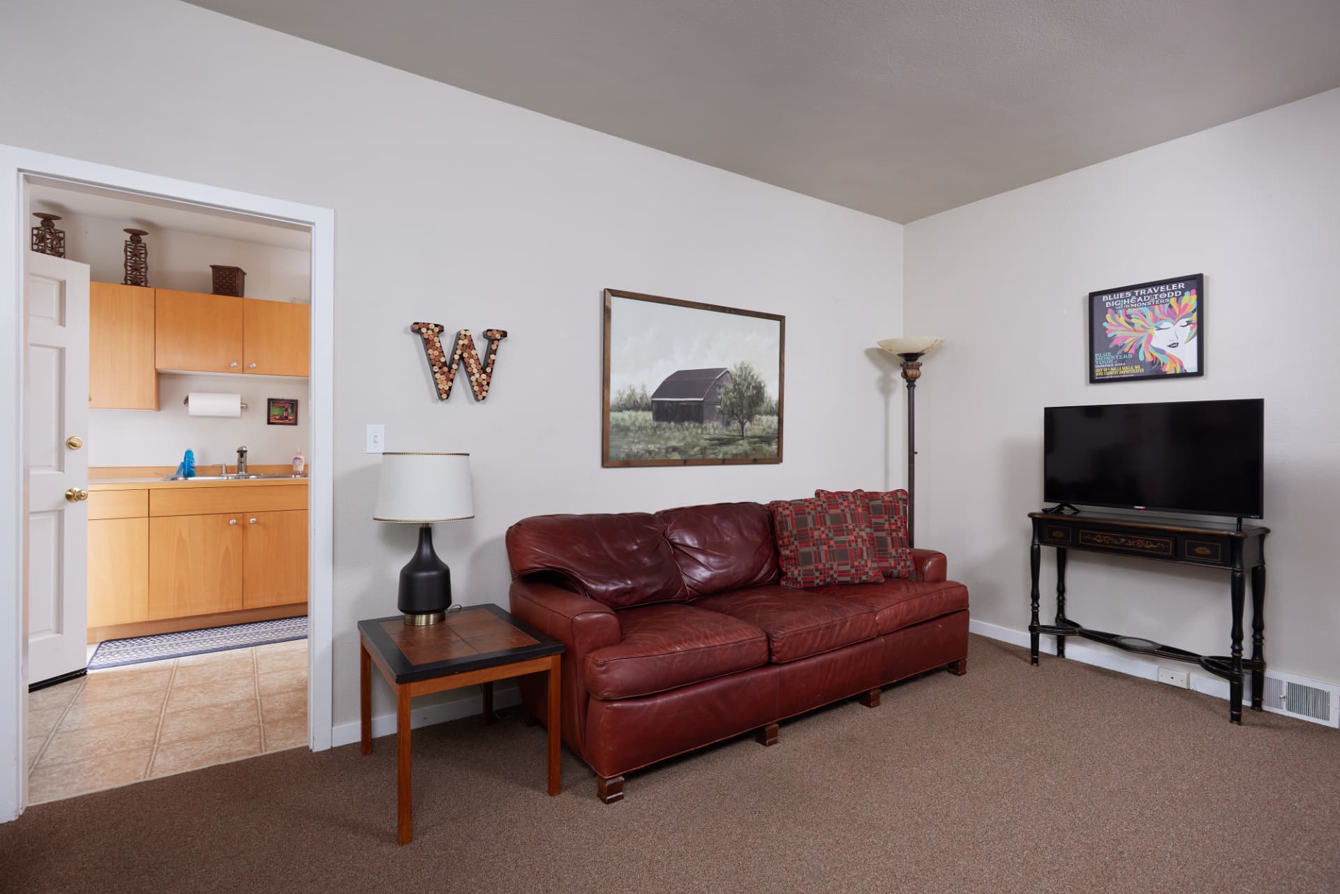 The Cabernet living area with wine-country artwork and warm lamplight